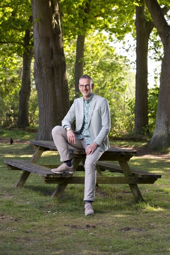 Bestuurslid Ansfried Snijders poseert op een picknicktafel.