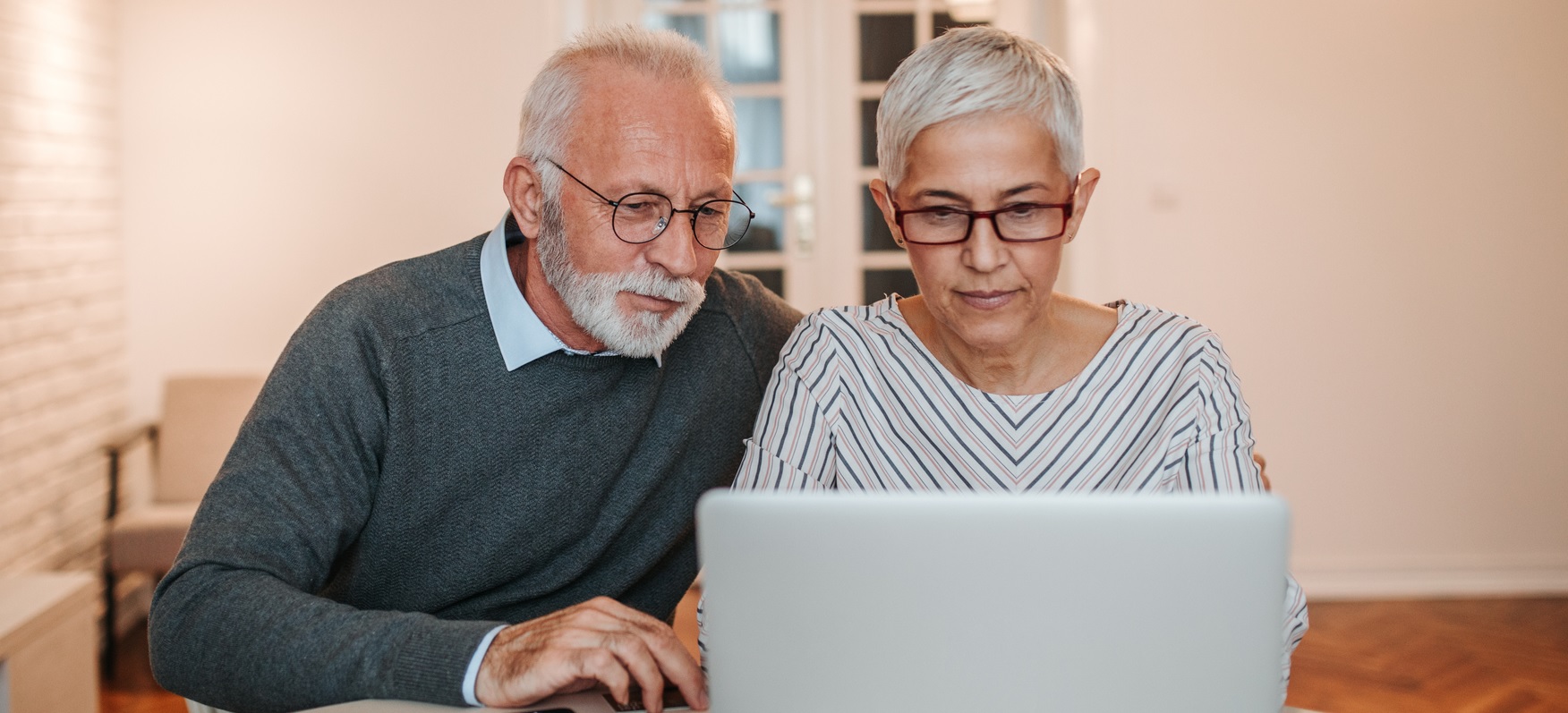 Een man en een vrouw zitten samen achter een laptop.